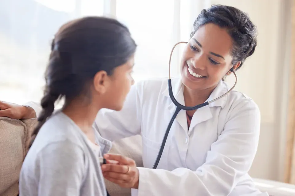 Primary Care Pediatric Nurse Practitioner Taking Heart Rate of Child Patient